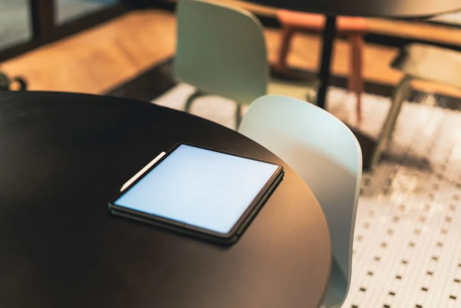 A sleek office desk setup featuring Apple devices: iMac, MacBook, and iPad.
